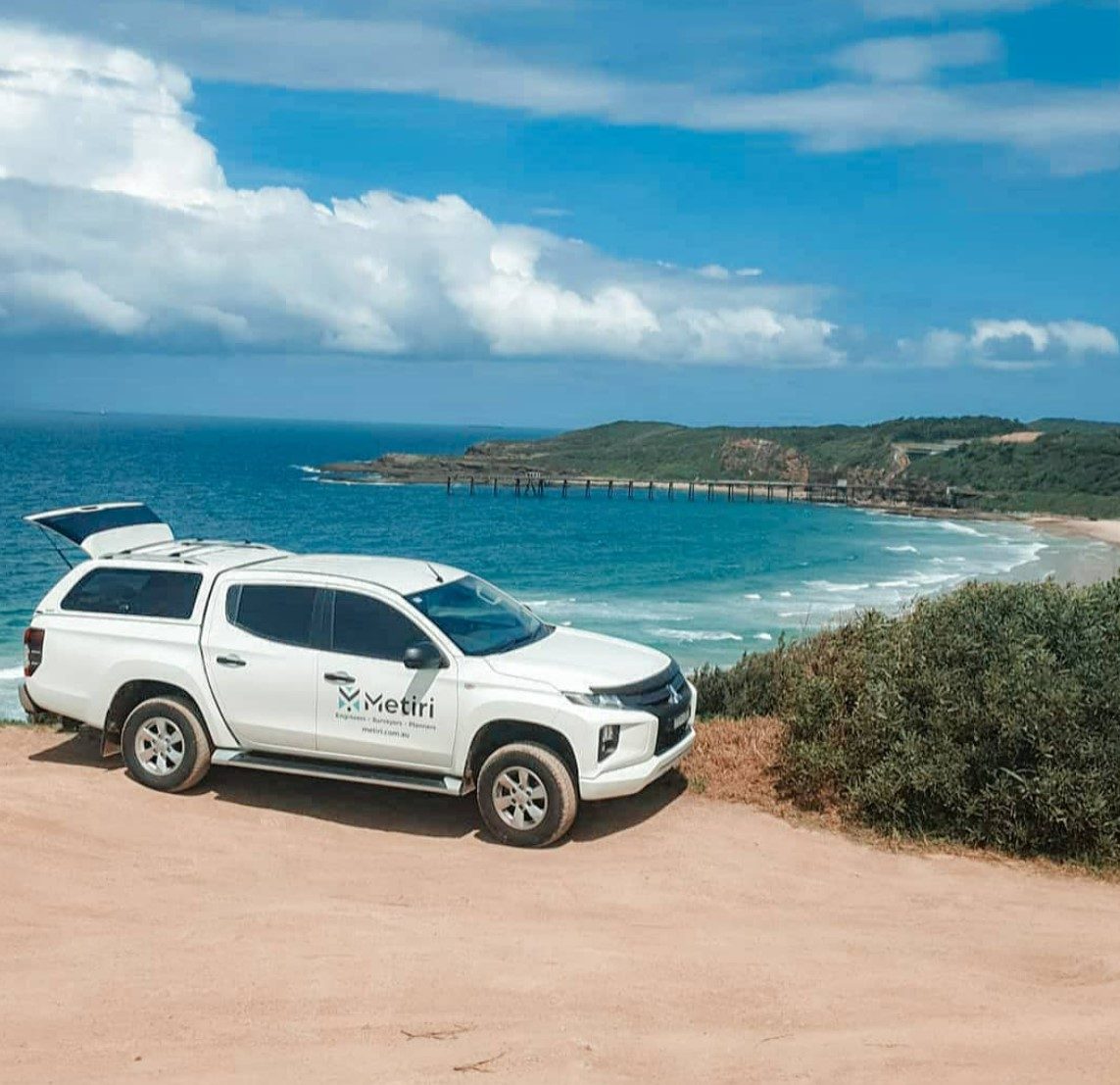 The Metiri ute parked above a beach and jetty on the coast